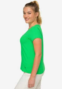 Zielona bawełniana koszulka z okrągłym dekoltem i krótkimi rękawami, wyróżniająca się dopasowanym krojem i małym logo na dolnym obszyciu.
