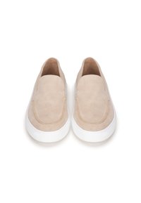 Scarpe slip-on in suede beige con punta arrotondata, suola in gomma bianca e cuciture visibili lungo il bordo. Texture liscia, design minimalista.