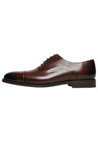 Scarpa oxford in pelle marrone con punta arrotondata e finitura liscia. Presenta cinque asole e un tacco leggermente rialzato. Design semplice.