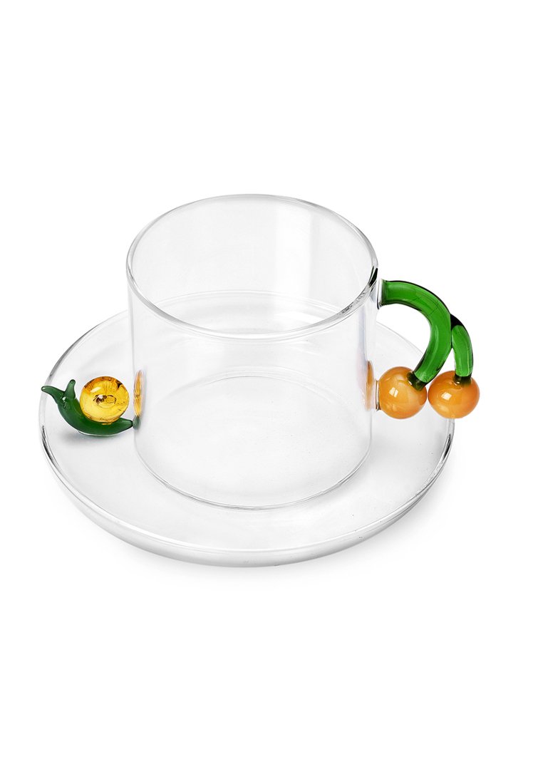 Przezroczysta szklanka z okrągłym dnem, zielonym uchwytem i pomarańczowymi akcentami. W komplecie z dopasowanym przezroczystym spodkiem.