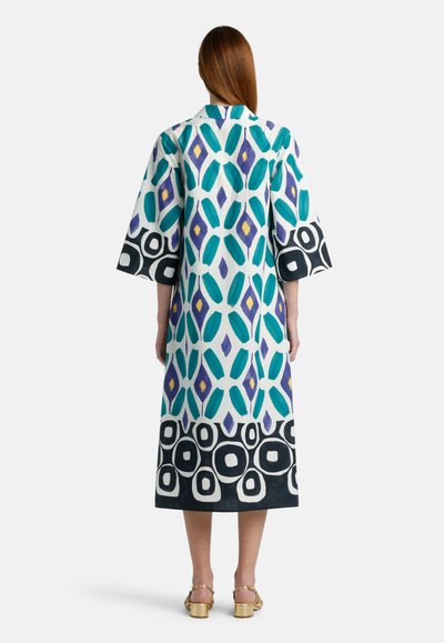 Pitkä, kuvioitu kimono teal-värissä, purppurassa ja mustassa. Ominaisuuksiin kuuluvat ylisuuret hihat ja rohkea, geometrinen reuna. Sileä kangastunne.