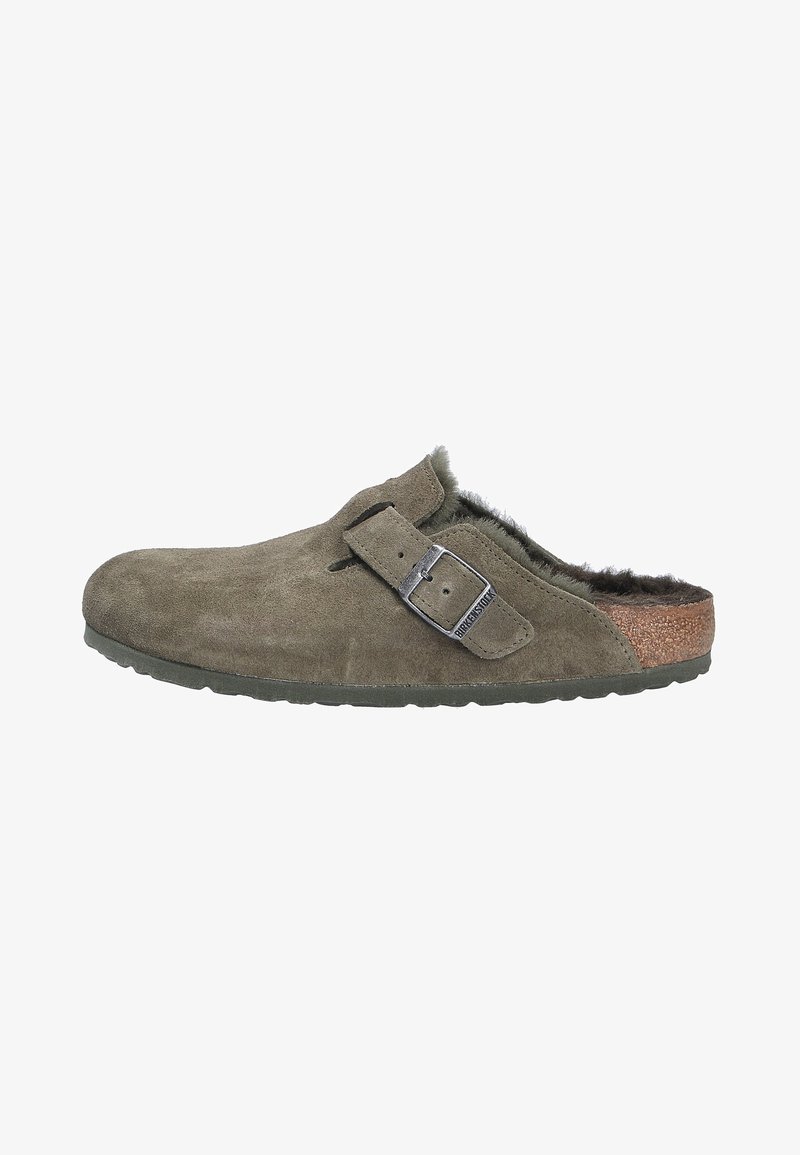 Mule de ante gris-verde con forro de pelo, correa ajustable y media suela de corcho. Cuenta con una suela de goma texturizada para agarre y durabilidad.