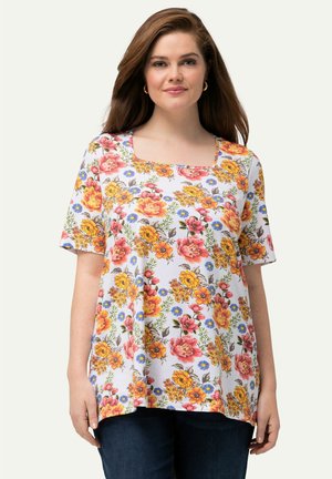Top floreale a maniche corte con scollatura quadrata, con fiori gialli, rosa e blu su uno sfondo bianco, realizzato in tessuto leggero.