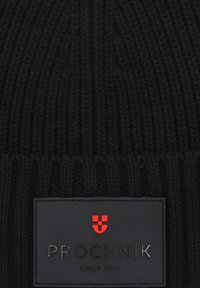 Czarna dziana czapka z ryflowanym wzorem, z prostokątną naszywką logo w czerni i czerwieni, z napisem "PRÓCHNIK" oraz "SINCE 1948."