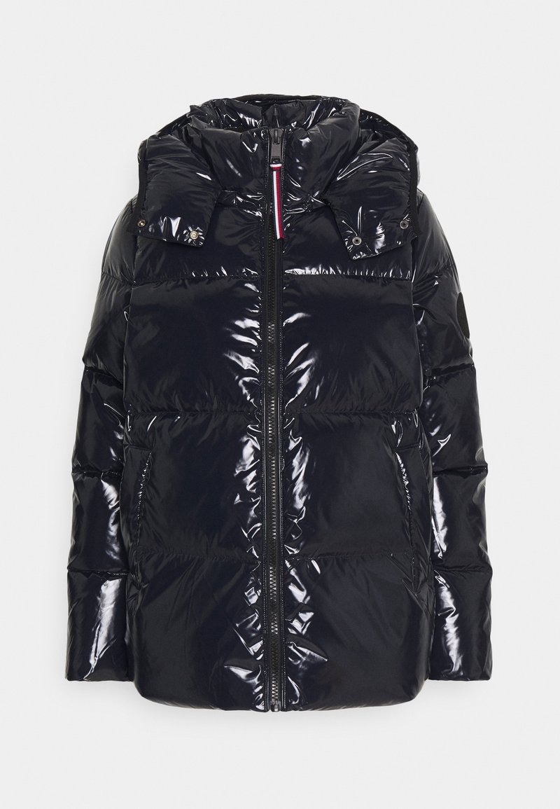 Veste d’hiver matelassée noire brillante avec col montant, fermeture éclair à l’avant, deux poches latérales et capuche amovible avec boutons-pression.