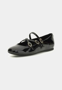 Ballet flats in vernice nera con multiple cinghie sottili e decorazioni circolari in tono oro, caratterizzate da punta arrotondata e tacco minimale.
