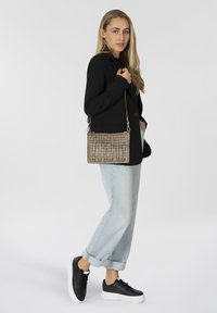 Borsa rettangolare di media grandezza realizzata in materiale beige testurizzato con motivo a griglia, dotata di una tracolla e di finiture in argento.