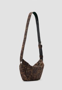 Bolso de hombro de estampado de leopardo con una correa de cuero oscura, forma redondeada y cremallera lateral. Textura suave, diseño compacto para uso diario.
