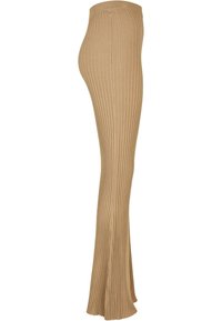 Bež hlače od rebrastog pletenog materijala s raširenim rubom i elastičnom strukom, s okomitim prugama za teksturu i elegantnom siluetom.