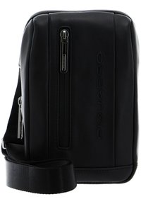 Borsa a tracolla in pelle nera con una superficie liscia, tasca anteriore con zip singola e tracolla in tessuto regolabile. Presenta un marchio impresso.