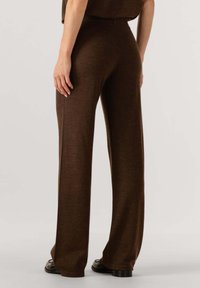 Bruine wijde broek met een zachte textuur, met een hoge tailleband en een nette afwerking aan de zoom. Minimalistisch ontwerp, zonder zichtbare hardware.