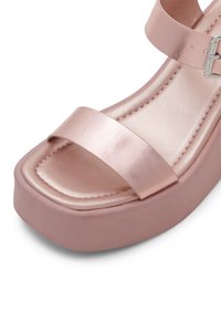 Růžové platformové sandály s kovovým leskem. Mají dvě široké pásky přes chodidlo a texturovanou podrážku, navržené pro pohodlí a stabilitu.