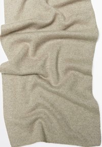 Écharpe en tricot beige clair avec une texture douce, présentant un design en côtes, drapée pour montrer sa forme fluide et ses plis naturels.