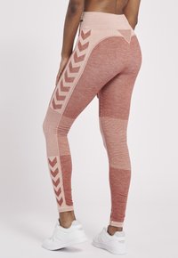 Röda leggings i blandad färg med strukturerade paneler och chevron-accenter, som har en hög midja och kontrasterande ljusrosa detaljer.