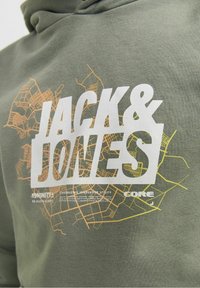 Sweat à capuche vert olive avec un grand logo texte blanc "JACK & JONES", orné d'un motif de carte de ville abstraite avec des accents jaunes et oranges.