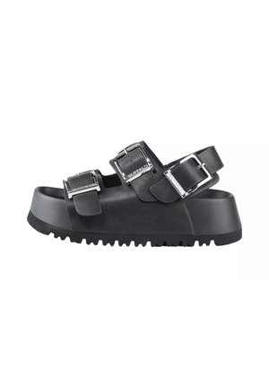 Sandale plateforme noire avec trois boucles argentées réglables et semelle crantée, cuir végétalien, vue de côté.