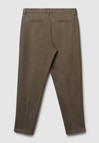 Braune maßgeschneiderte Herrenhose mit Gürtelschlaufen und zwei aufgesetzten Gesäßtaschen, auf einem hellgrauen Hintergrund flach ausgelegt.