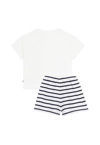 T-shirt blanc en coton à manches courtes associé à un short rayé bleu marine et blanc, avec une taille élastique et une coupe décontractée.