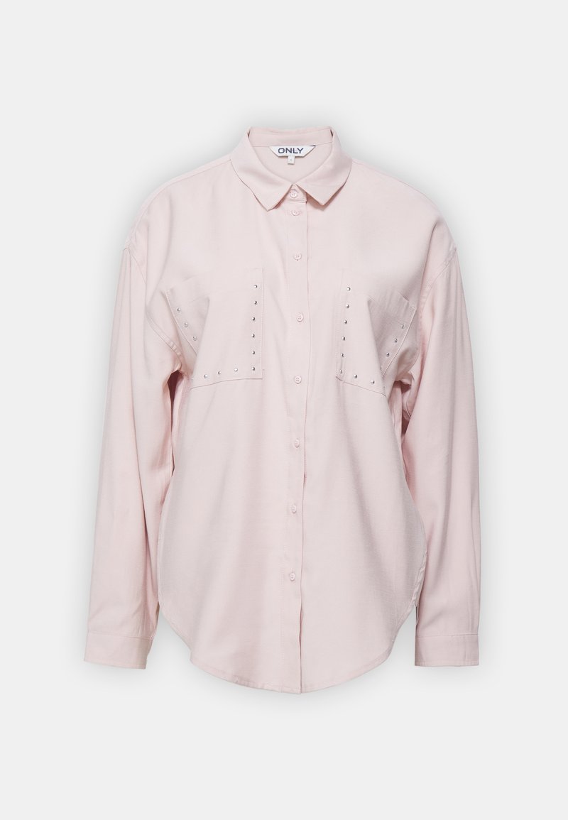 Chemise longue à manches longues rose clair avec un col, deux poches poitrine et des rivets décoratifs sur les poches. Tissu doux avec une coupe décontractée.