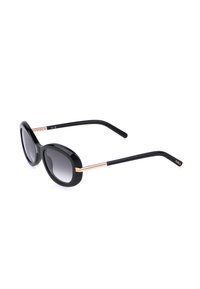 Lunettes de soleil ovales noires avec verres dégradés foncés, branches fines noires et dorées, et branding Furla sur les extrémités des branches.