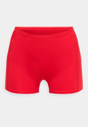 Crvene kupaće gaće izrađene od glatkog, elastičnog materijala. Imaju visok pojas i uski kroj s zaobljenim otvorima za noge.