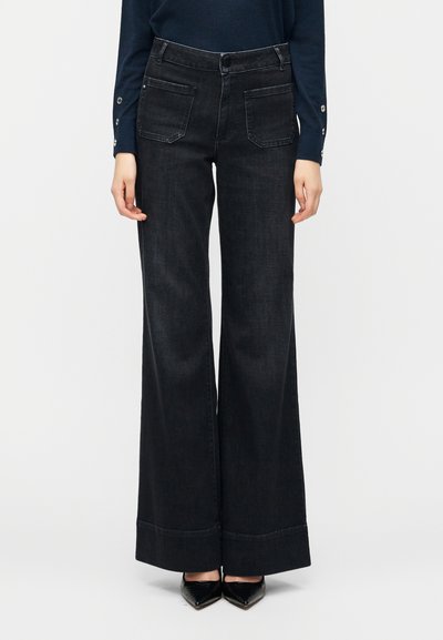Dunkelblaue Jeans mit weitem Bein verfügen über eine hohe Taille, Fronttaschen und einen sauberen Saum. Der Stoff hat eine glatte Textur mit subtiler Dehnbarkeit.