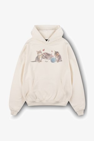 Sudadera con capucha beige que presenta un gráfico de tres gatitos juguetones y una bola de hilo, con sutiles detalles de mariposas encima. Tela suave con un bolsillo frontal.