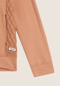 Felpa a maniche lunghe in un delicato pesco, con un pannello a maglia texturizzato e etichetta con logo, che mette in mostra una finitura del tessuto liscia e maniche a polsino.