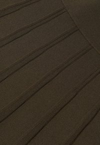 Rövid ujjú, sötét olajzöld kötött anyag, függőleges bordázott textúrával és finom mintázattal. Puha, közepes súlyú anyag.