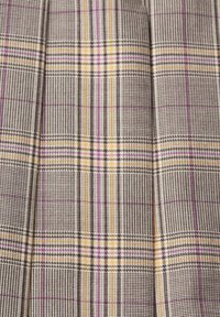 La tela de cuadros presenta un patrón de rejilla en gris, amarillo y púrpura, con una textura fina y pliegues ordenados, mostrando un tejido intrincado.