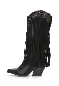 Bota de vaquero de cuero negro con detalles de flecos, punta afilada y acentos de tachuelas en la parte superior. Tacón grueso con una base en contraste.