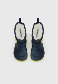 Bottes imperméables marine avec une douce doublure en fourrure blanche, dotées d'un accent vert et d'une boucle en haut pour un enfilage facile. Bout carré et semelle texturée.