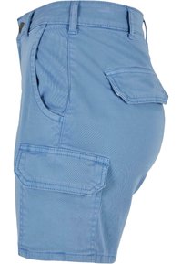Short cargo bleu clair avec plusieurs poches à rabat et passants pour ceinture, vu de profil avec un focus sur la taille et le haut de la cuisse.