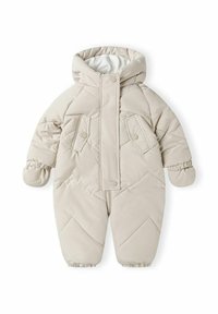 Overall bej cu umplutură, dotat cu glugă, cu închidere prin butoane în față, două buzunare frontale și manșoane elastice pentru căldură și confort.