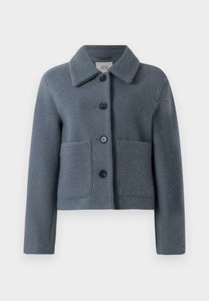 Blau-graue, strukturierte Wolljacke mit breitem Kragen, Knopfverschluss vorne und zwei großen aufgesetzten Taschen, vor einem weißen Hintergrund präsentiert.