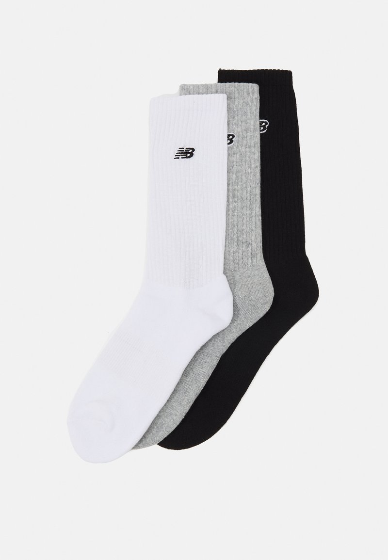 Pakke med tre stripete sokker i hvit, grå og svart, med en liten svart New Balance-logo på hver sokk.