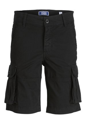 Person iført en rustfarvet kortærmet skjorte med knapper, sorte cargoshorts, hvide sokker og sort-hvide sneakers, stående på en hvid baggrund.