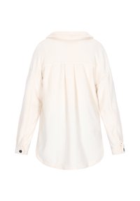 Krämfärgad flanellskjorta med krage, långa ärmar och knappmanchetter. Bakdelen har en plisserad design för extra textur.