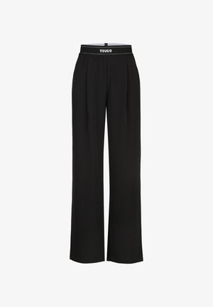 Schwarze Hose mit weitem Bein und elastischem Bund mit dem weißen Schriftzug "19V69" vorne in der Mitte.