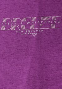 T-shirt violet en tissu texturé avec un texte imprimé blanc qui dit "FRESH & WHISPERING BREEZE SUN TOUCHED et heureux."