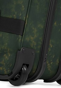 Dunkelgrüner Koffer mit texturiertem Oberflächen, schwarzem Zubehör und einem einzelnen Rad für Mobilität, mit dezenten goldenen Marmorierungsakzenten.