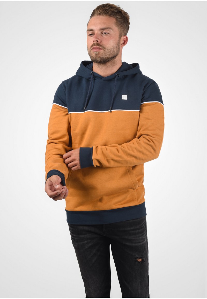 Kapuzensweatshirt mit einem navyblauen oberen Teil und einem orangefarbenen unteren Teil, versehen mit einem weißen horizontalen Streifen und einem kleinen Logo auf der Brust. Baumwollmischgewebe.