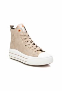 Zapatillas altas beige con textura de cuero suave, puntera de goma blanca y suela de plataforma con acentos naranjas y detalle de logo circular.