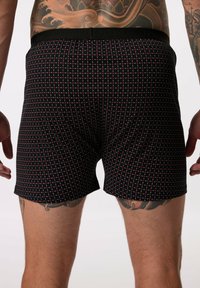 Zwarte boxershorts met een ruitpatroon van kleine rode en witte vierkanten. Zachte stof met een elastische tailleband.