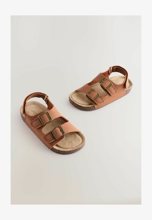 Sandalias marrones con correas ajustables dobles, parte superior de piel sintética texturizada, suelas de goma similares al corcho y una plantilla suave color tostado.