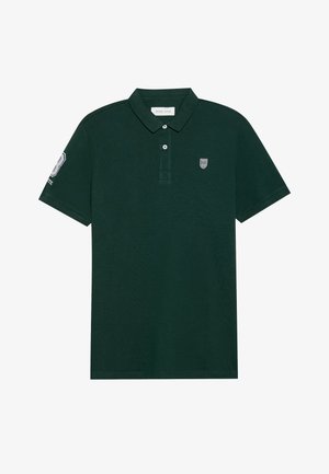 Polo shirt vert foncé en tissu texturé, avec un col classique, deux boutons et des logos brodés sur la poitrine et la manche.