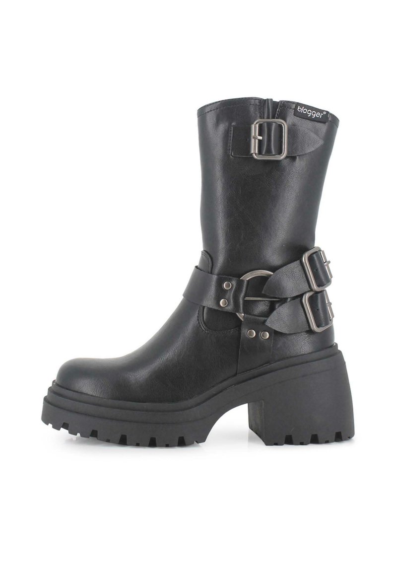 Botines negros con suela de plataforma gruesa, que presentan una textura similar al cuero suave, dos correas ajustables y un detalle de hebilla lateral.