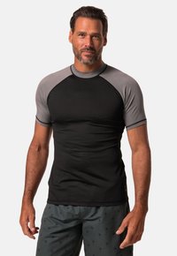 Krótki rękaw rash guard wykonany z gładkiej czarnej tkaniny z szarymi rękawami raglanowymi. Posiada okrągły dekolt i dopasowany krój, idealny do aktywności fizycznej.