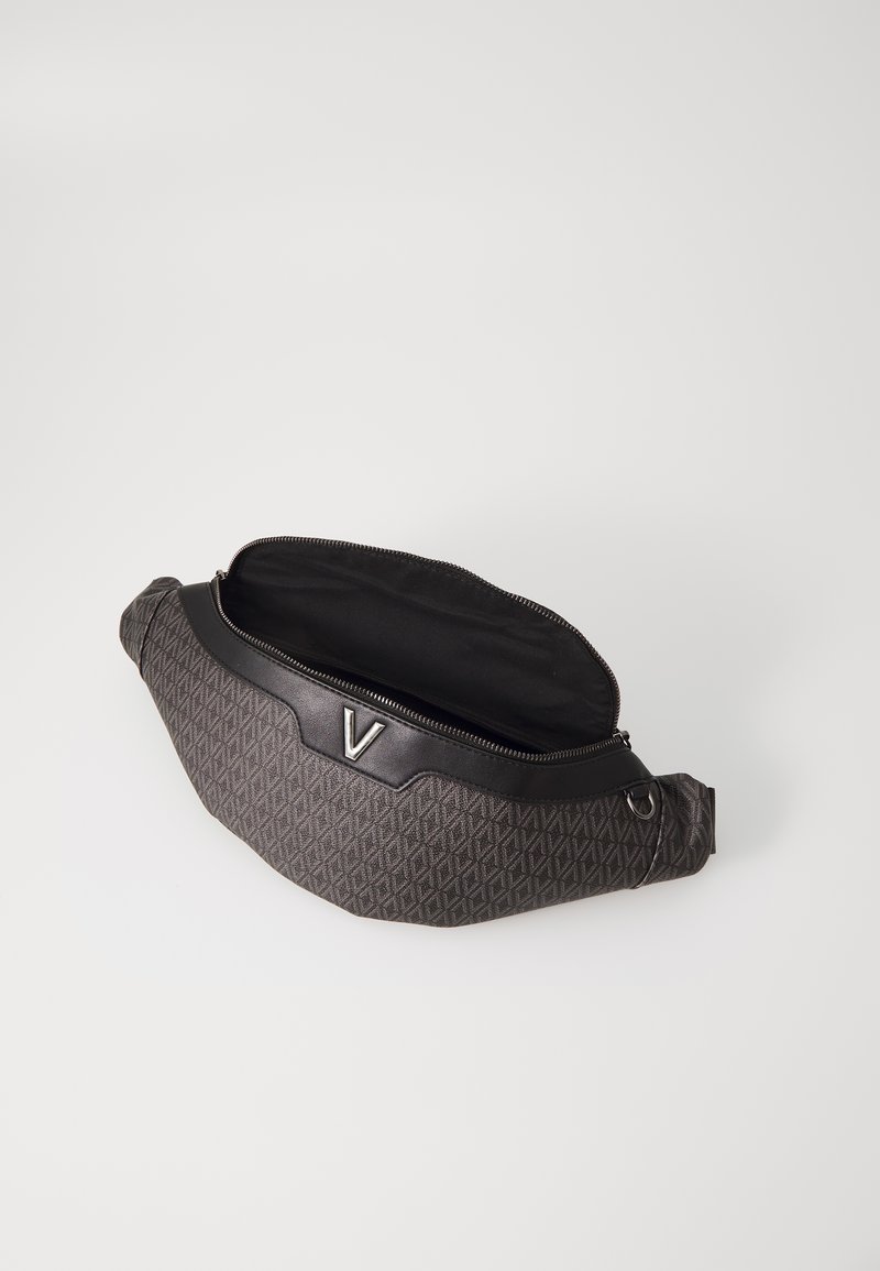Sac banane noir à motif avec une texture en diamant, présentant un accent en cuir lisse et un logo argenté. La fermeture éclair ouverte révèle l'intérieur.