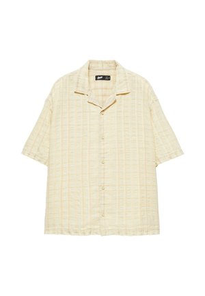 Chemise beige à manches courtes avec un motif subtil à rayures verticales et un col camp, présentée sur un fond blanc.